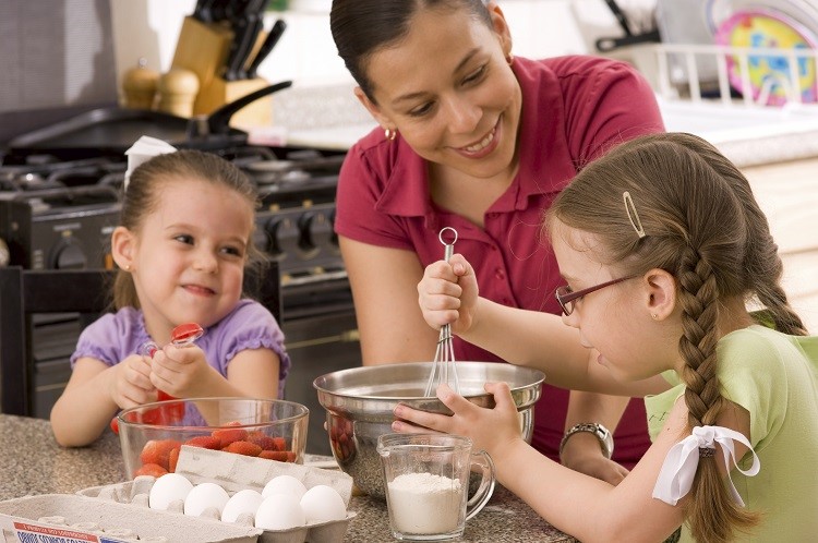 Two girls cooking with their mother